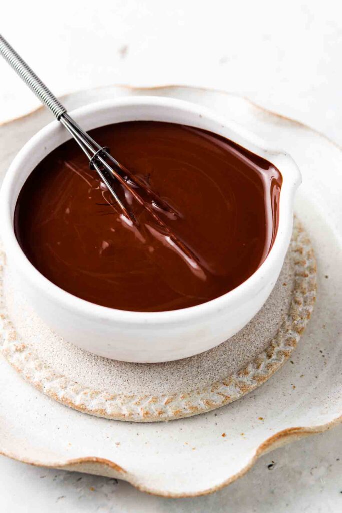 vegan chocolate ganache in a bowl with a whisk