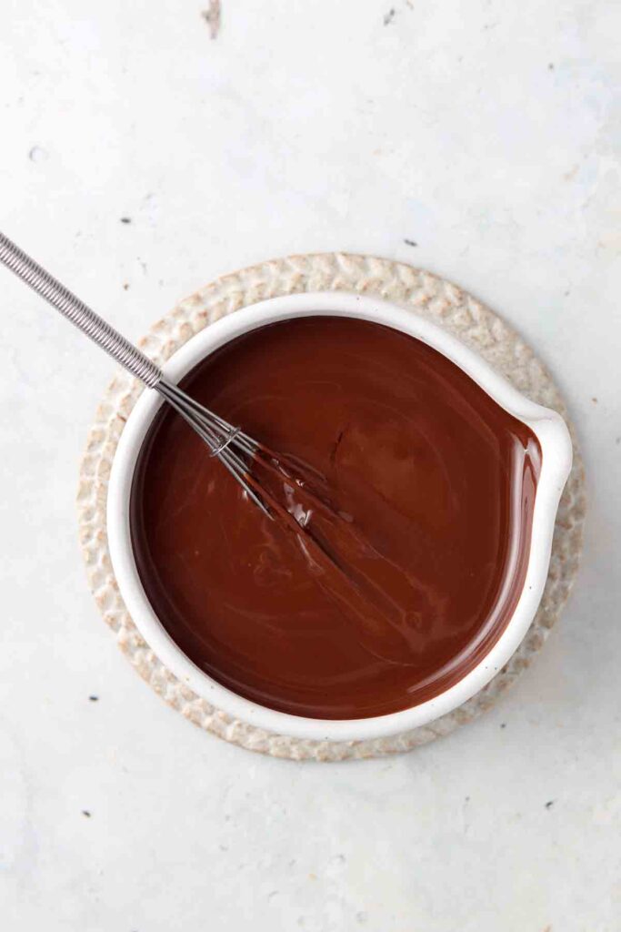 vegan chocolate ganache in a bowl with a whisk