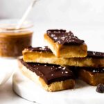 Vegan and gluten free twix bars stacked up on a plate with