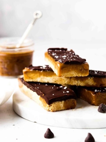 Vegan and gluten free twix bars stacked up on a plate with