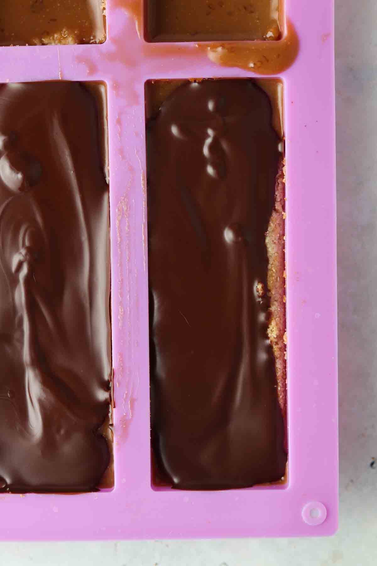 Homemade chocolate bars in a pink mold.