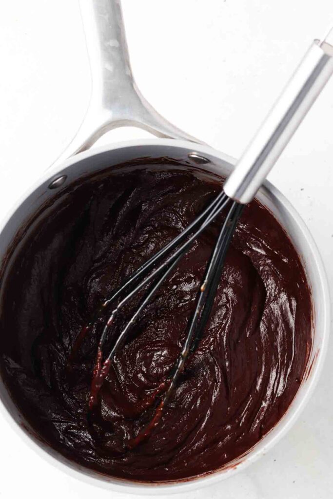 Dairy free chocolate and coconut milk whisked together in a sauce pan.