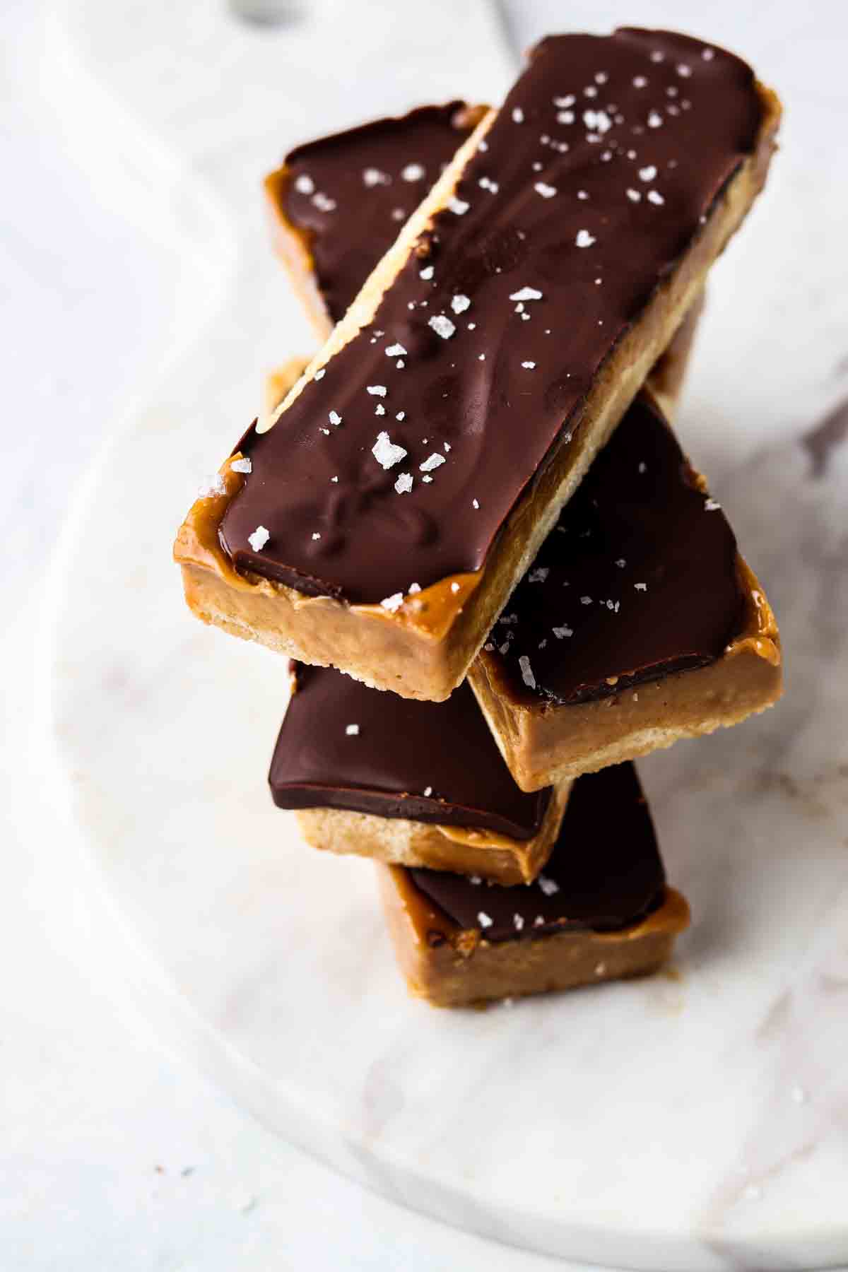 4 stacked homemade twix bars on a marble plate.