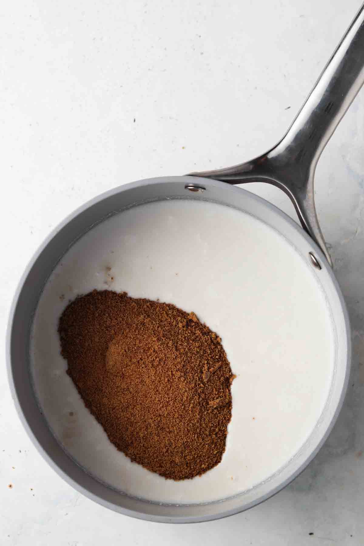 Coconut milk and coconut sugar in a sauce pan on the stove.