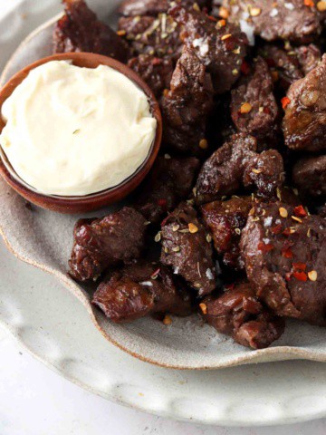 steak bites on a plate with garlic aioli