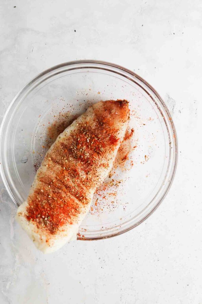 blackened seasoning and cod in a bowl mixed