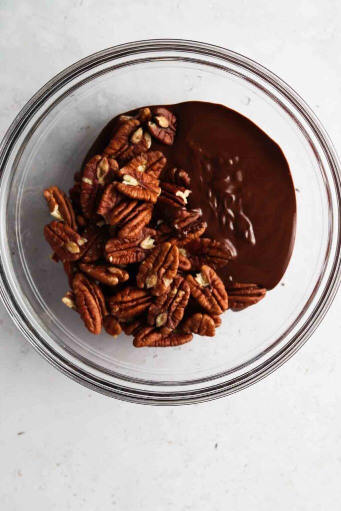 melted chocolate and pecans in a bowl