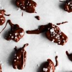 chocolate covered pecans on a baking sheet with sea salt