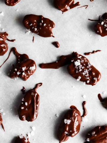 chocolate covered pecans on a baking sheet with sea salt