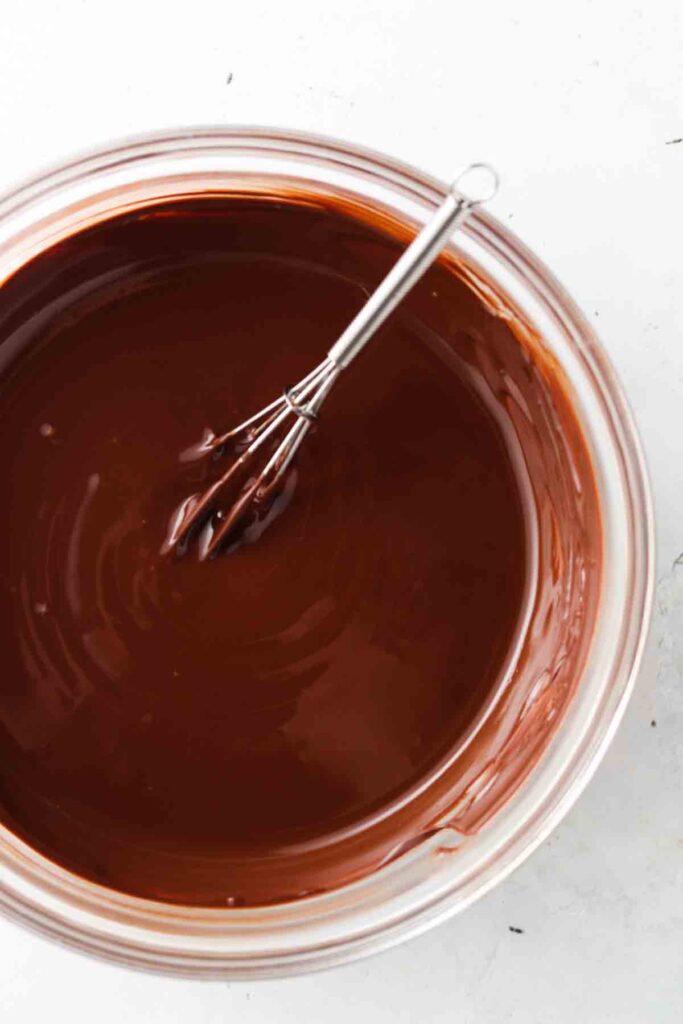 melted chocolate in a bowl with a whisk