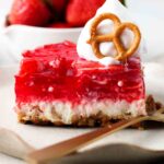 dairy free strawberry pretzel salad on a plate with whipped cream on top