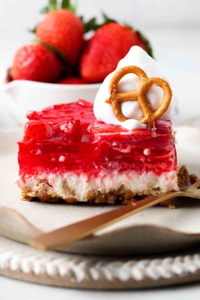 dairy free strawberry pretzel salad on a plate with whipped cream on top