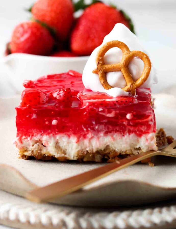 dairy free strawberry pretzel salad on a plate with whipped cream on top