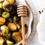 brussel sprouts on a plate with a honey wand