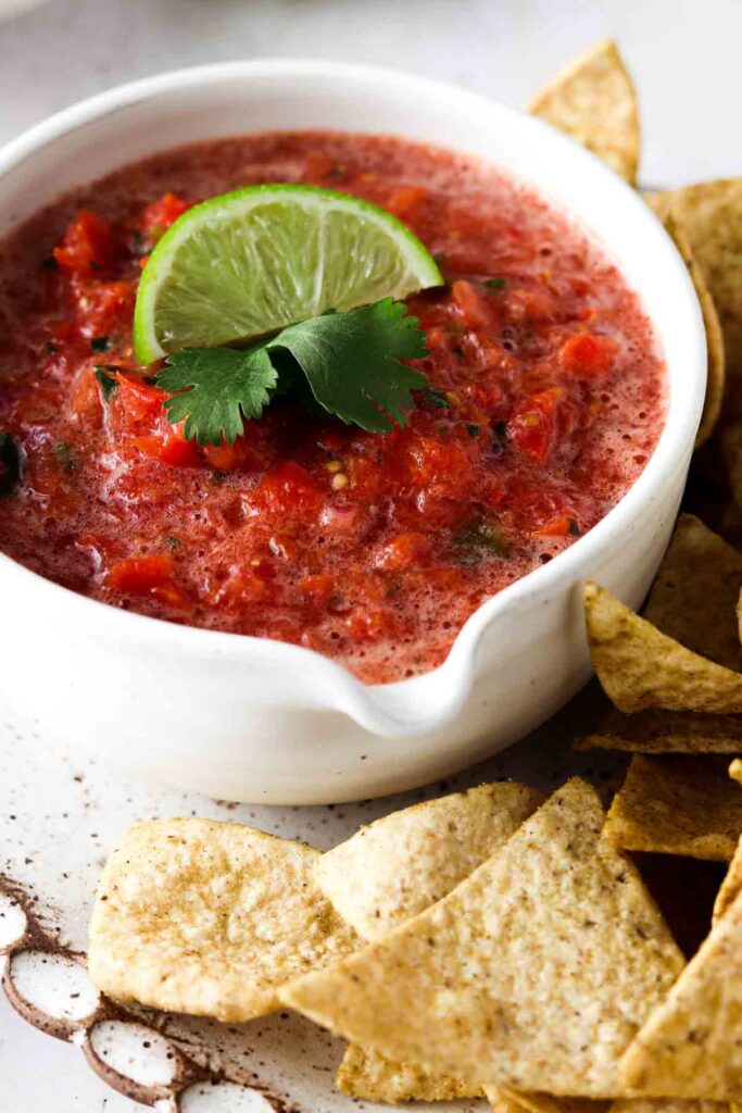 keto salsa in a bowl with a lime and cilantro on top with low carb chips on the side