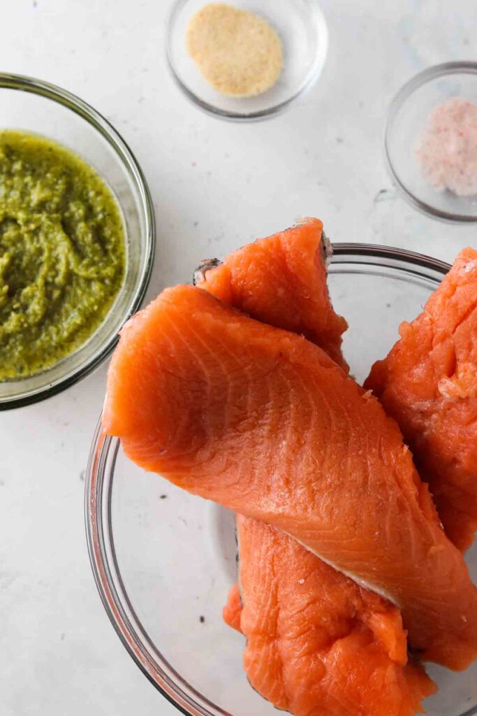 salmon, pesto, garlic powder and sea salt laid out in bowl