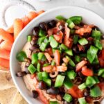 overhead shot of taco dip with celery, carrots and chips on a plate