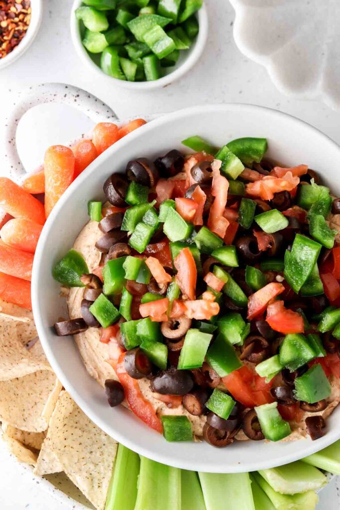 overhead shot of taco dip with celery, carrots and chips on a plate