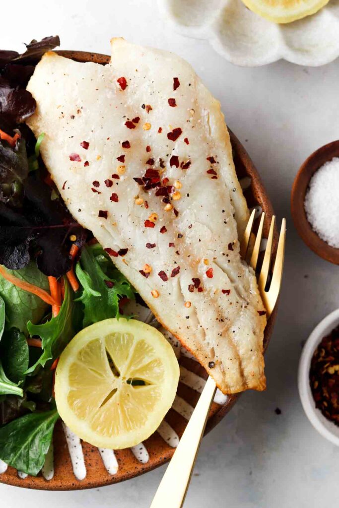 fish on a plate with mixed greens