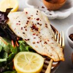 air fried cod on a plate with mixed greens