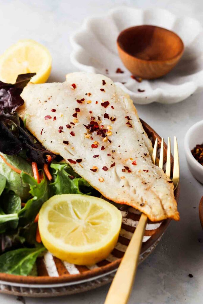 air fried cod on a plate with mixed greens