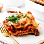 piece of lasagna with gluten free noodles and cashew cheese on a plate