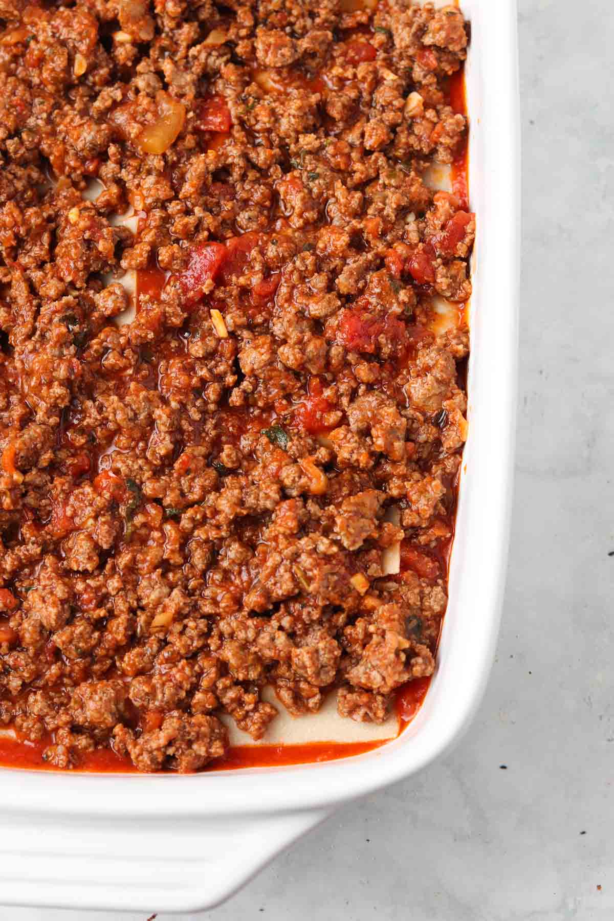 Ground beef sauce layered on top of lasagna noodles. 