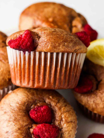 raspberry muffins stacked on a plate