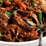 close up photo of pulled pork in a bowl