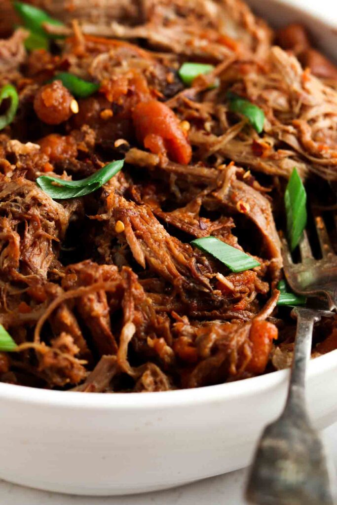 close up photo of pulled pork in a bowl