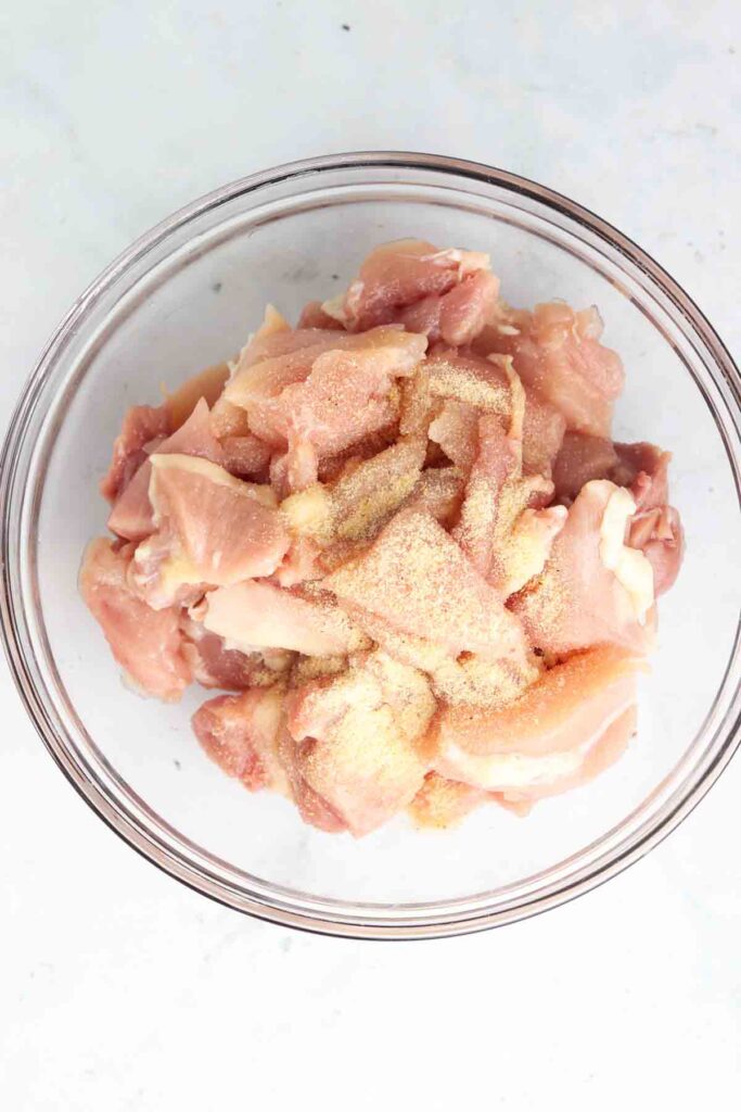 raw chicken in a bowl with seasoning