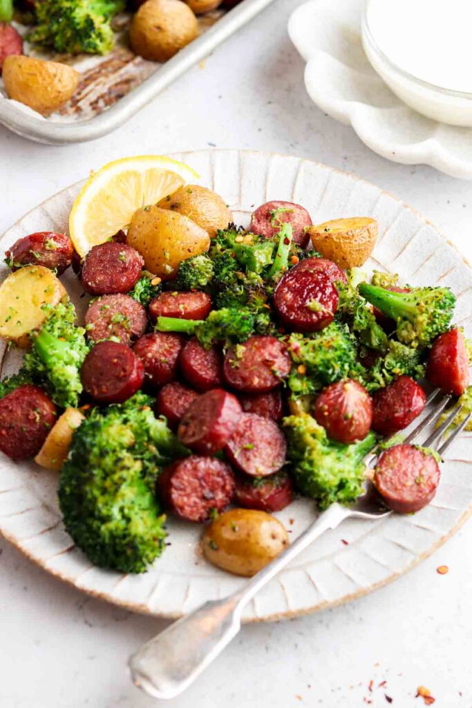 sausage, broccoli and potatoes on a plate with a fork and garlic aioli