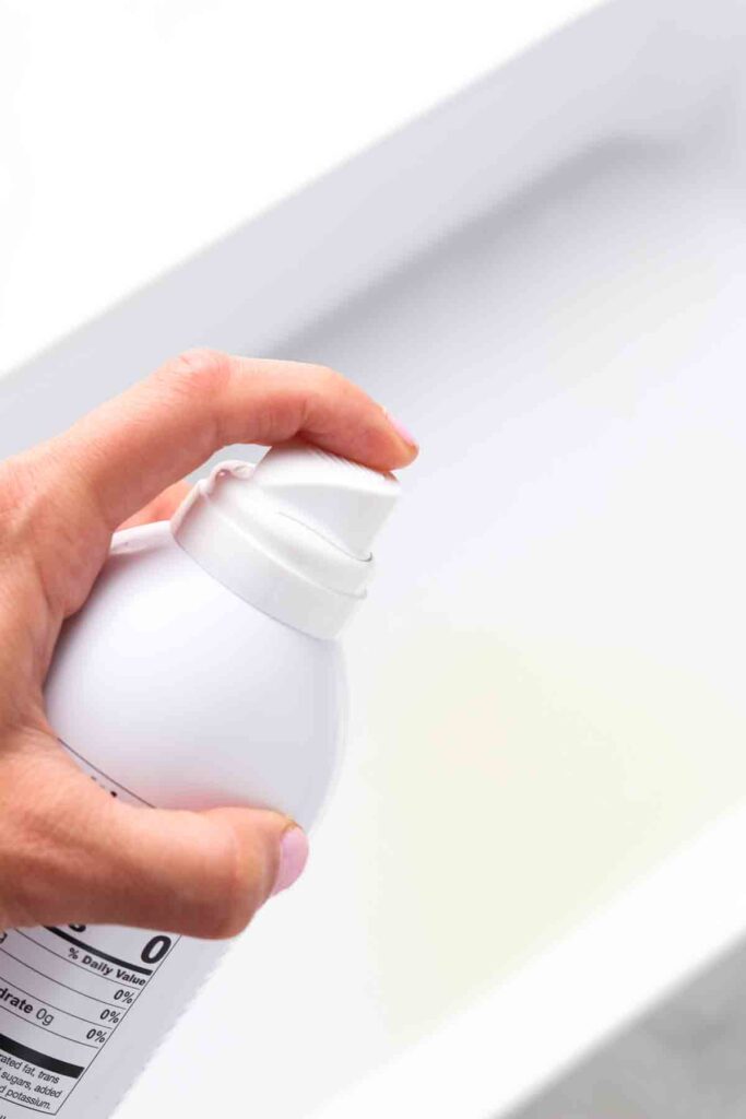 oil being sprayed in a casserole dish