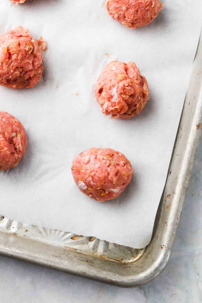 rolled meatballs on a baking sheet