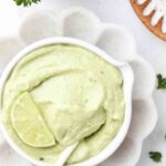 avocado lime ranch dressing in a bowl with a lime on top