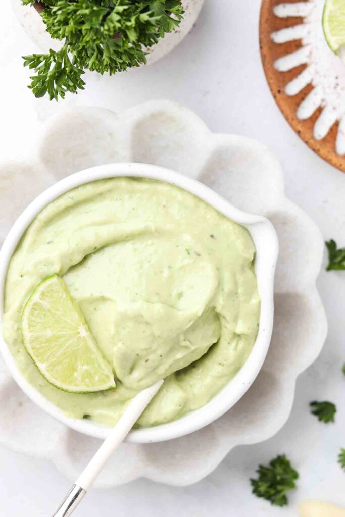 avocado lime ranch dressing in a bowl with a lime on top