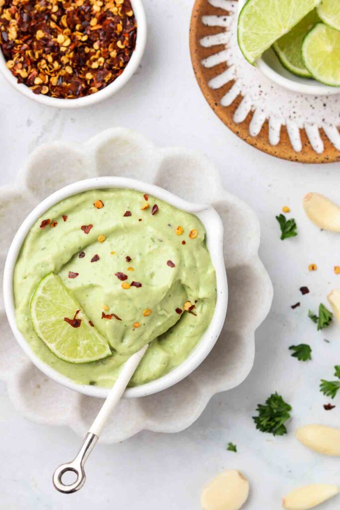 avocado lime dressing overhead shot with red pepper flakes sprinkled on top