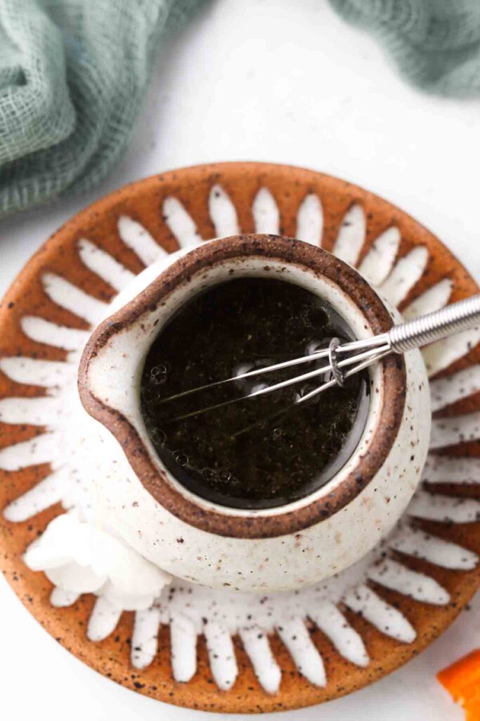 orange poppyseed salad dressing in a bowl with a whisk