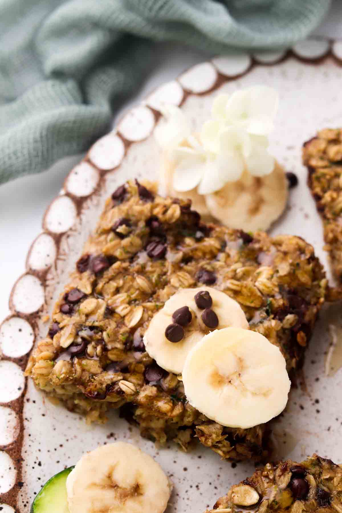 Zucchini oatmeal bars on a plate with fresh bananas.