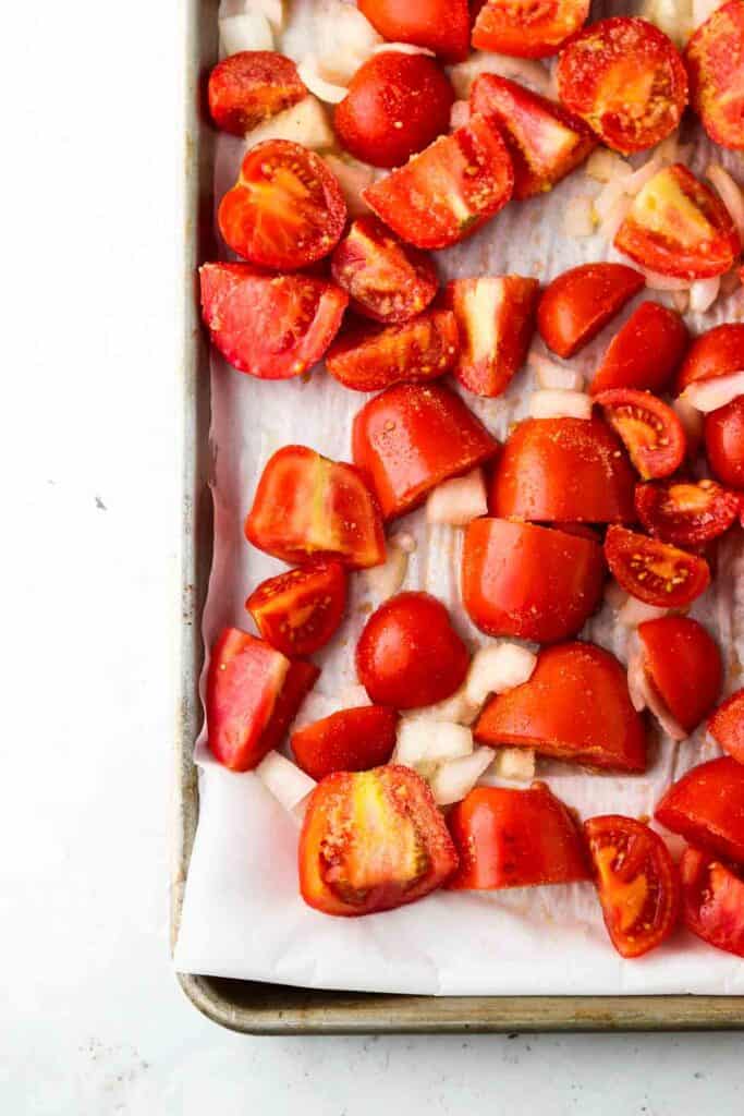tomatoes and onions on a sheet pan
