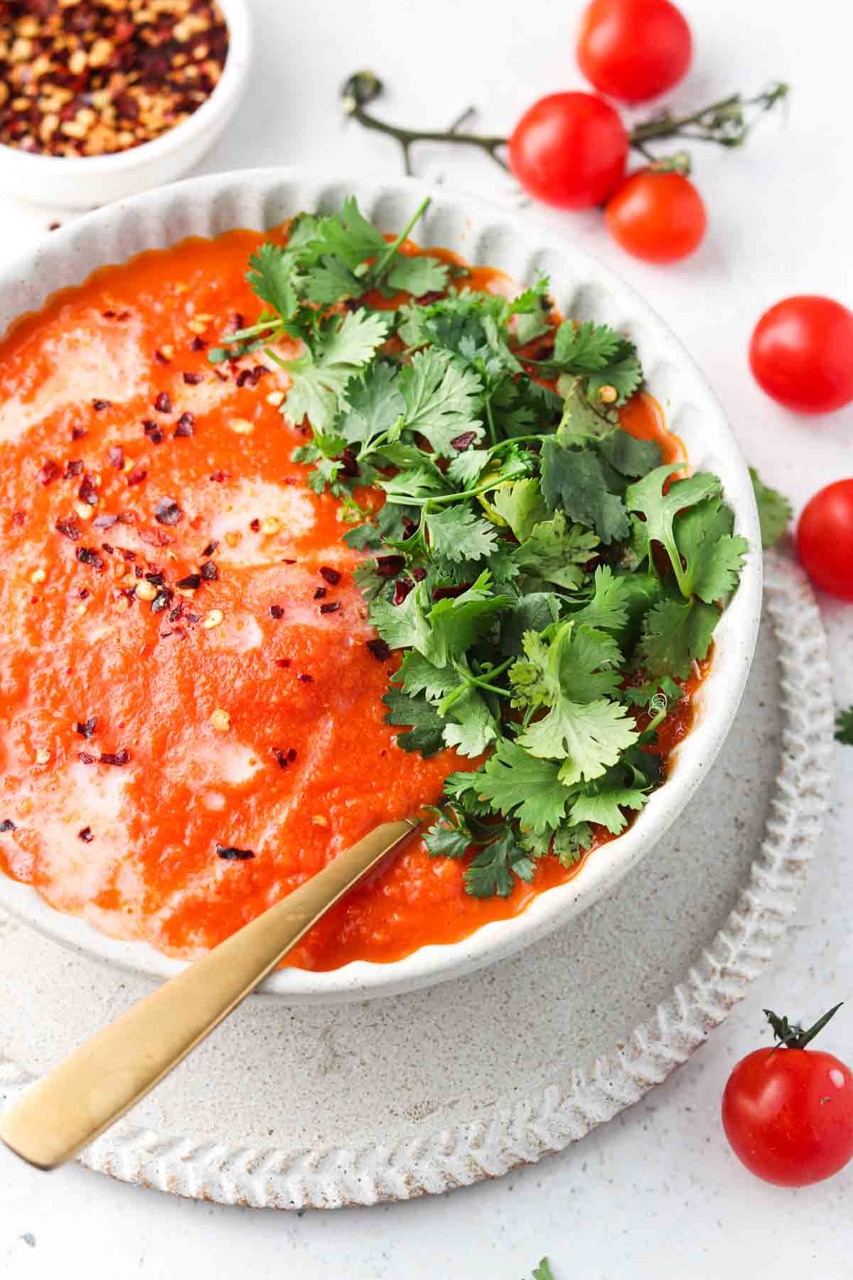 Tomato soup with red pepper flakes and fresh parsley on top.