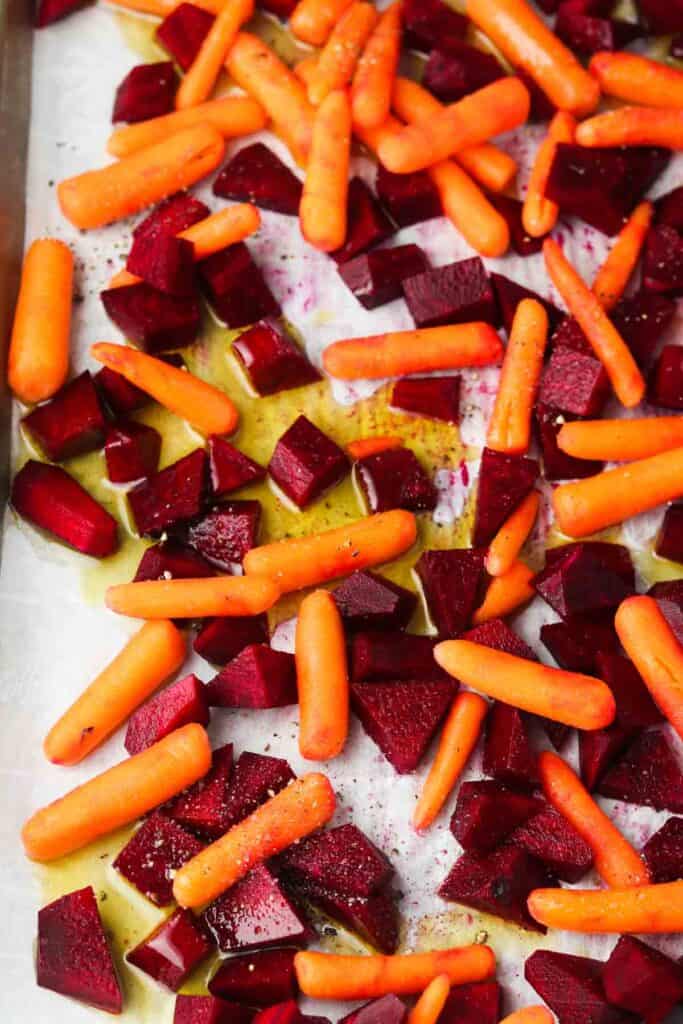 marinated beets and carrots laid out on a sheet pan