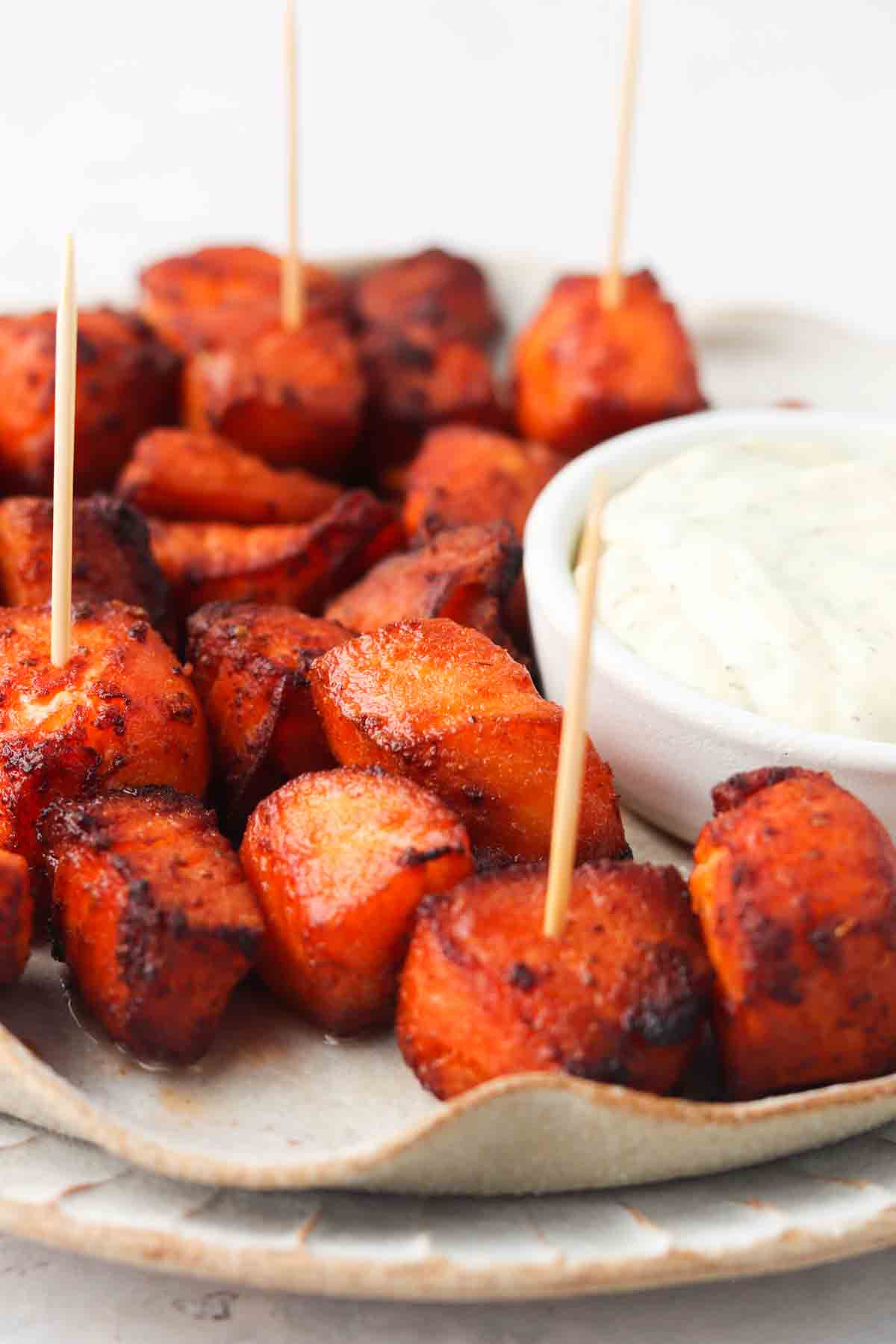 Salmon bites on a plate with toothpicks.