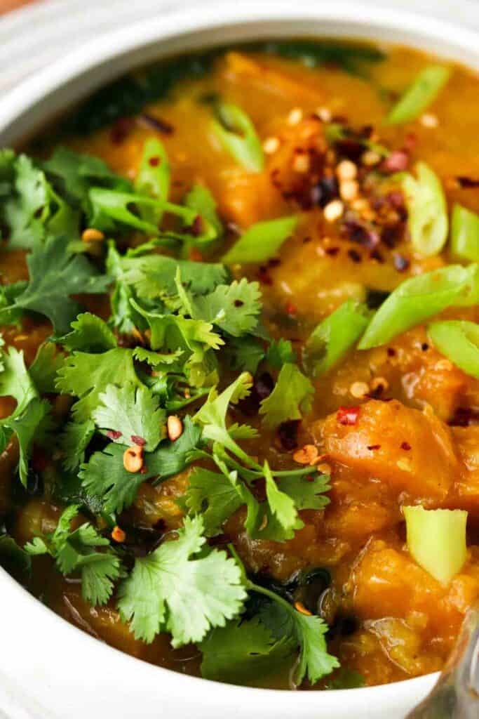 butternut squash in a bowl with fresh herbs on top