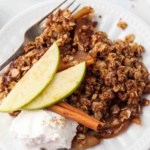 apple crisp on a plate with whipped cream