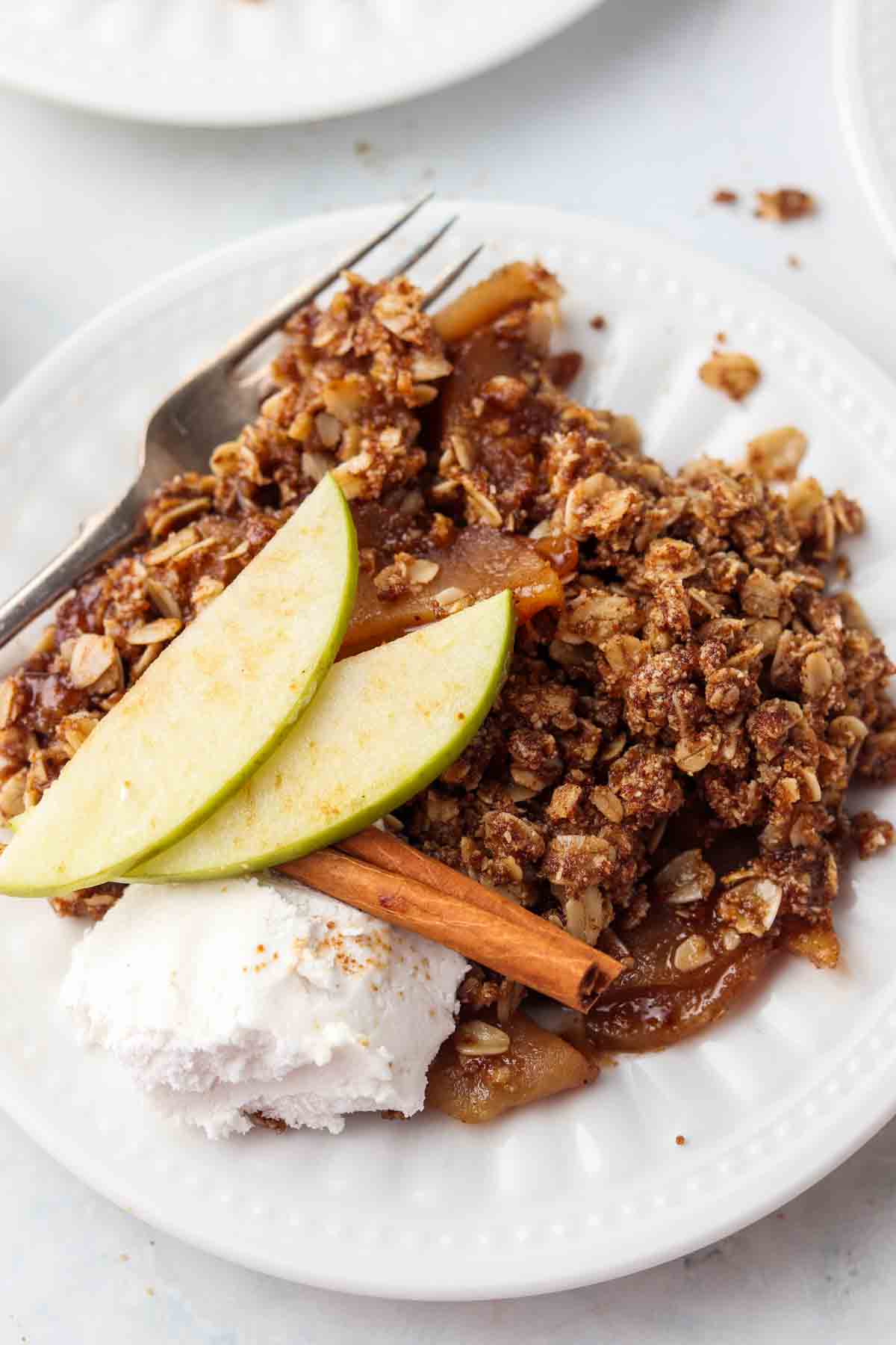 apple crisp on a plate with whipped cream