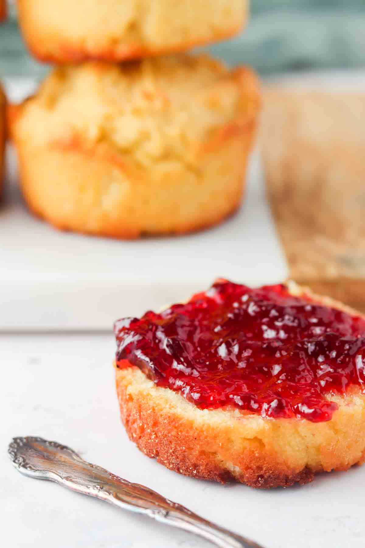 Biscuit with jelly on top sitting on a plate.