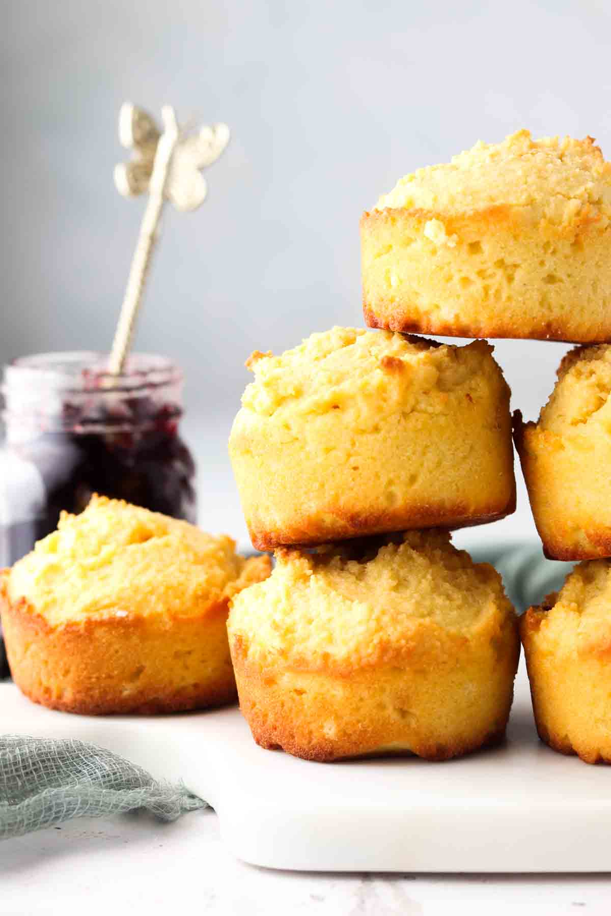 Biscuits stacked on top of each other with a jar of jelly next to it.