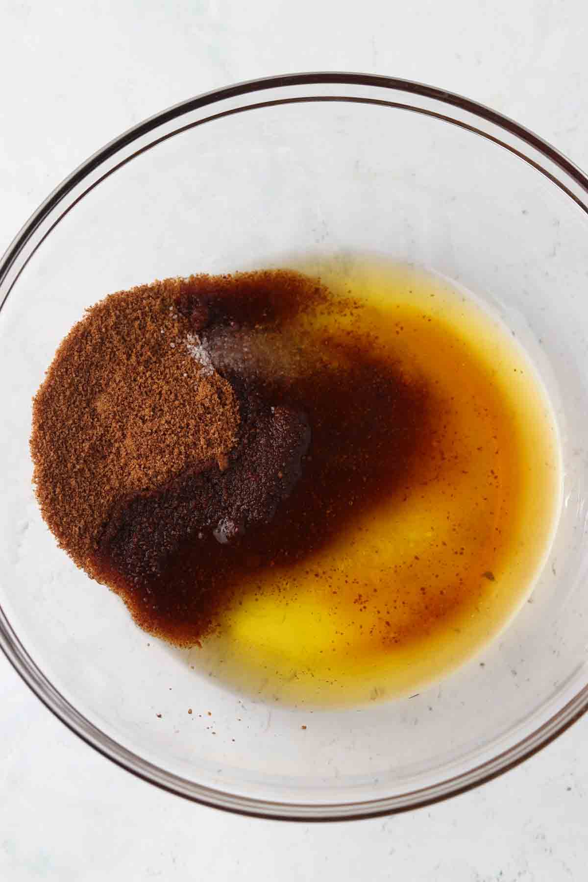 Coconut sugar, vanilla, and ghee in a glass mixing bowl.