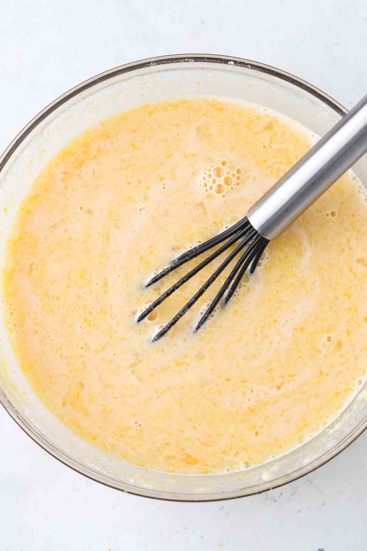 Lemon filling for bars being whisked together in a bowl.